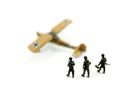 Miniature people : team soldier standing together with army tank and aircraft air combat using for...