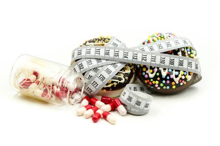 Donut tying by measuring tape and drug Capsule of medicine,dietary for slim shape concept,Take medicine, drug for diet in concept.の写真素材