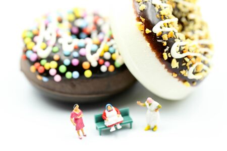 Miniature people : Fat old man sitting on tape Measure with junk foodの写真素材