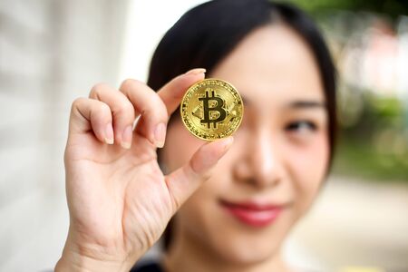 Selective of focus with Businesswoman holding the bitcoin gold coin