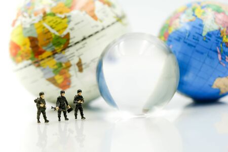 Miniature people : soldiers team with world map,War, army, military, guard concept.の写真素材