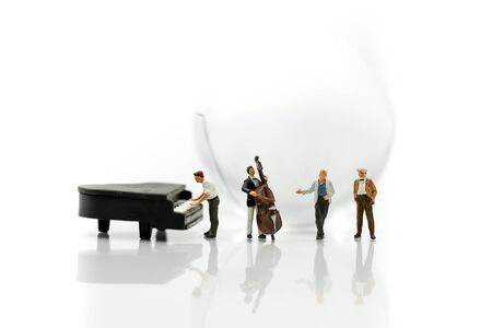 Miniature people : pianist playing piano and Violinist Man with mini world glass, playing musical instrument concept.の写真素材
