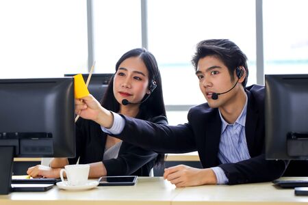 Asia Group of call center workers with headset in office.の写真素材