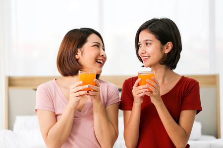 Happy young couple friend beautiful asia women drinking orange juice enjoying fruit refreshment ,Healthy lifestyle concept.の写真素材
