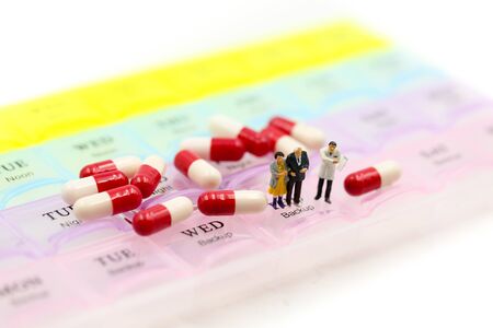 Miniature people : Doctor showing patient medication with Pill Box & Daily Medicineの写真素材