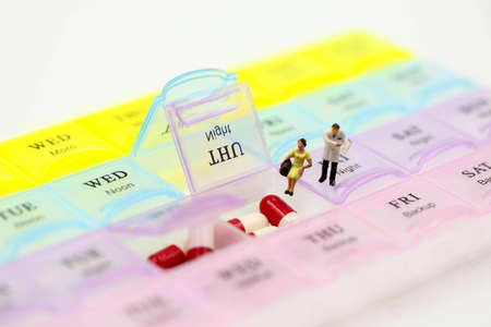 Miniature people : Doctor showing patient medication with Pill Box & Daily Medicineの写真素材