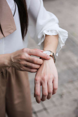Beautiful woman looking at her watch.の写真素材