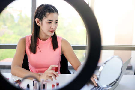 Asian woman beauty blogger or vlogger review cosmetic product Online influencer girl social media marketing.の写真素材