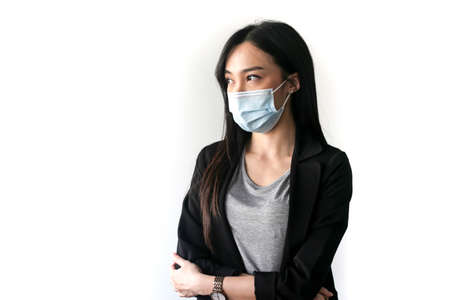 Beautiful Asian librarian woman  wear face masks  to prevent coronavirus, or COVID-19 she is...