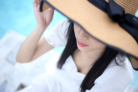 Close up Selective of focus Beautiful Asia woman relaxing near luxury swimming poolの写真素材