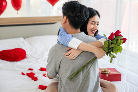 Couple in love hugging in the bedroom with rose and gift Valentine's Day  concept.の写真素材