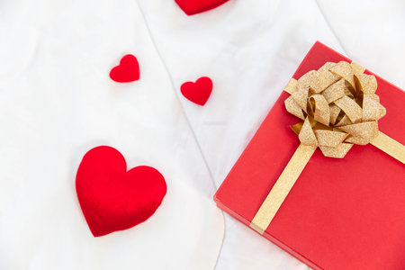 Heart shape with Gift box packed for honeymoon lover on white bed honeymoon suit.Valentine's day concept. Beautiful blurry background.heart lay on the bed.の写真素材