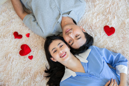 couples is laying on bed in the bed room with red heart shape Couple in Valentine day.Love couple,Relationship and couple concept.の写真素材