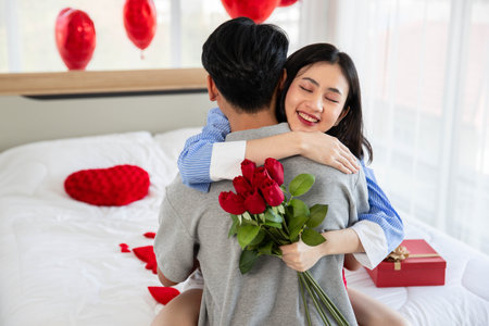 Couple in love hugging in the bedroom with rose and gift Valentine's Day  concept.の写真素材