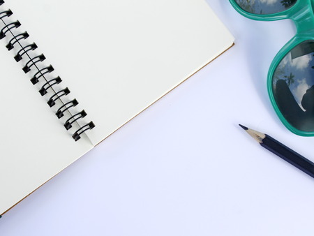 Notebook and black pencil On the white table
