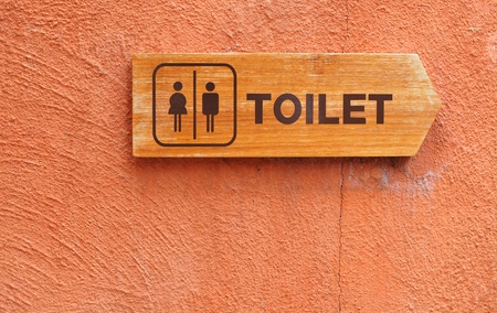 Toilet sign on an orange wall