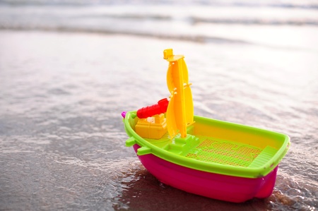 Plastic toy boat on a beach sandの写真素材