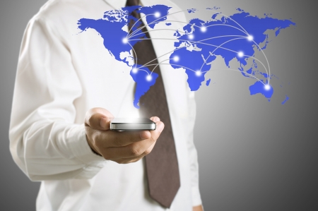 Business man showing smart phone with world map for social and internet connectivity conceptの写真素材