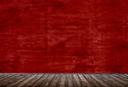 Empty room with red concrete wall and brown wooden planksの写真素材