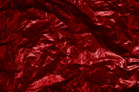 Background texture of red shiny foil with light reflectionの写真素材