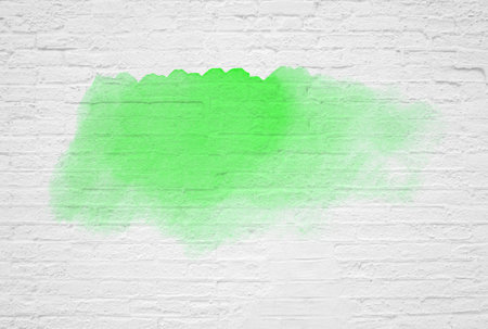 Old weathered brick white wall background texture with green graffitiの写真素材