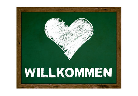 Chalkboard with wooden frame: Welcome in german language with painted heartの写真素材