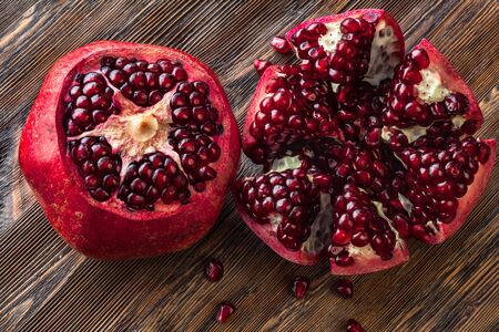 Two peeled pomegranates on wooden tableの写真素材