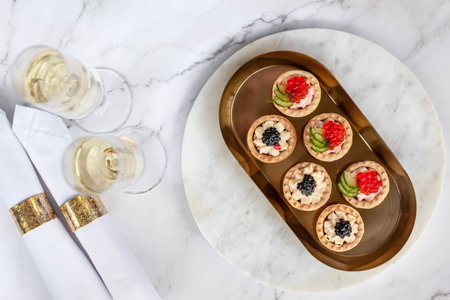 canape with black caviar and soured cream near glass with champagne. High quality photoの写真素材