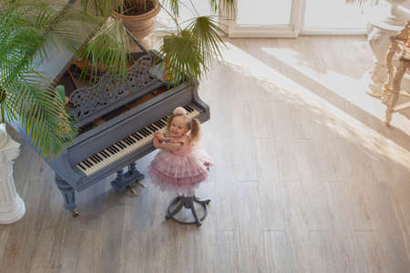 Overhead view of young girl playing grand piano in sunlight roomの写真素材