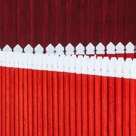 Wooden fence in front of red wallの写真素材