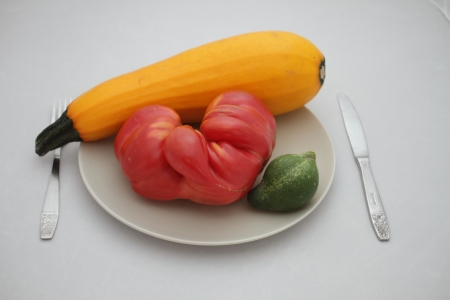  heart tomatoes, vegetables, zucchini, cucumber on a plateの写真素材