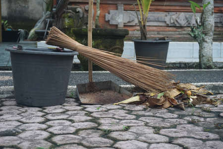 Garbage bucket, broom and trash bin to clean the yard from organic waste.