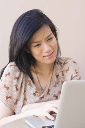Cute Asian Girl typing on laptopの写真素材