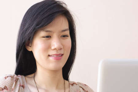 Cute Asian Girl typing on laptop