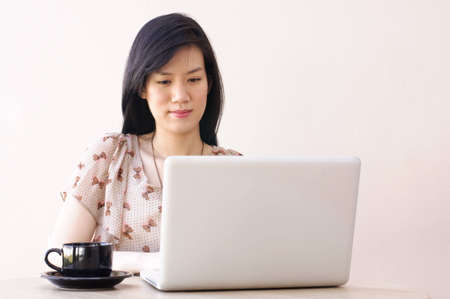 Cute Asian Girl typing on laptopの写真素材