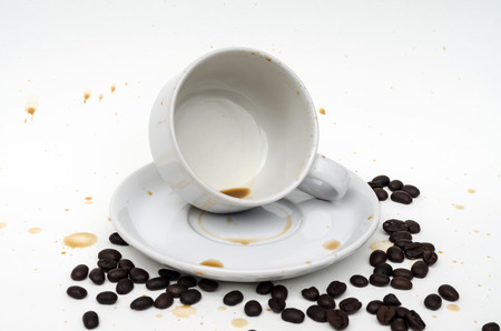 coffee in white cup with coffee beans and coffee stain