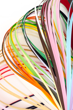 Colorful paper filigree strips in waves on white backgroundの写真素材