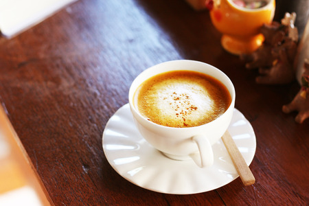 hot coffee latte in whute cup serve on wooden bar in coffee cafeの写真素材