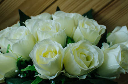 close up white rose in vase on wooden tableの写真素材