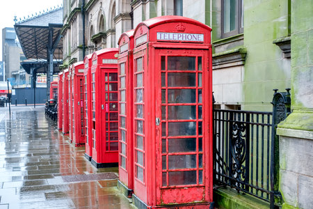 a row of red telephone boxes on a wet afternoonの写真素材