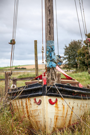 an old wooden sail boat lies in the grassの写真素材