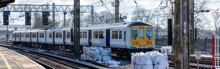 a white commuter train arriving at the stationの写真素材
