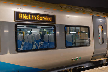 A train car at a station with a sign indicating Not in Service is illuminated by ambient light. This...