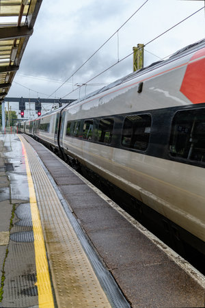 Sleek passenger train arriving at a platform, reflecting a busy travel hub.