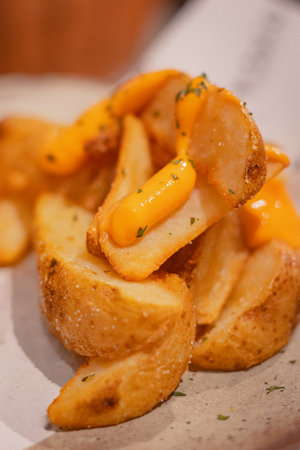 Close up, Deep-fried potato wedges with dipping cheese and tartar sauce on a round plate