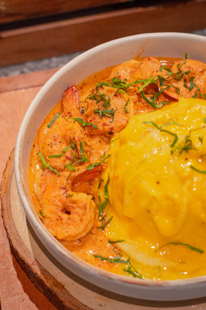 Close up, Creamy omelet with tom yum kung served with rice on dish, place on wooden boardの写真素材