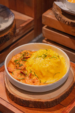 High angle, Creamy omelet with tom yum kung served with rice on dish, place on wooden boardの写真素材