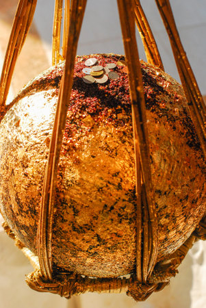 Round stones covered with gold leaf with coins on it, the stones buried to the ground in buddhist...