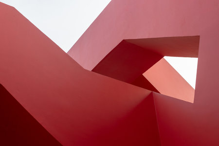 Abstract geometry of red architectural structure with clear skyの写真素材
