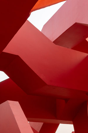 Abstract geometry of red architectural structure with clear skyの写真素材